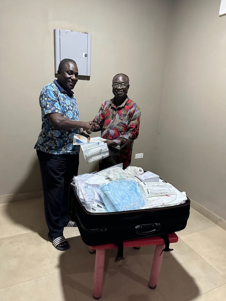 Two men exchanging medical supplies and shaking hands