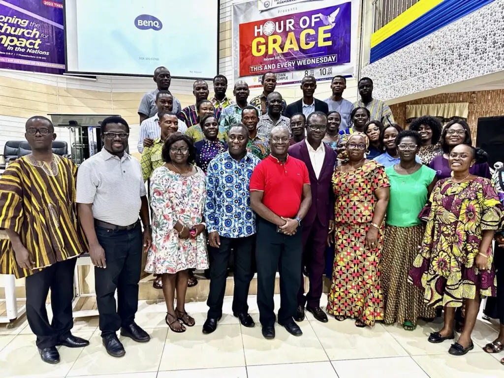 a large group of people posing for a picture in a church